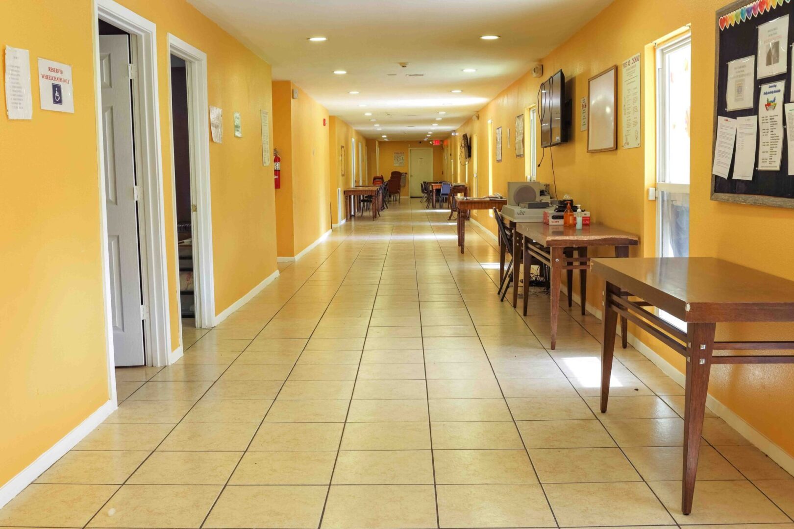 A clean, well-lit hallway with yellow walls and tiled floor.